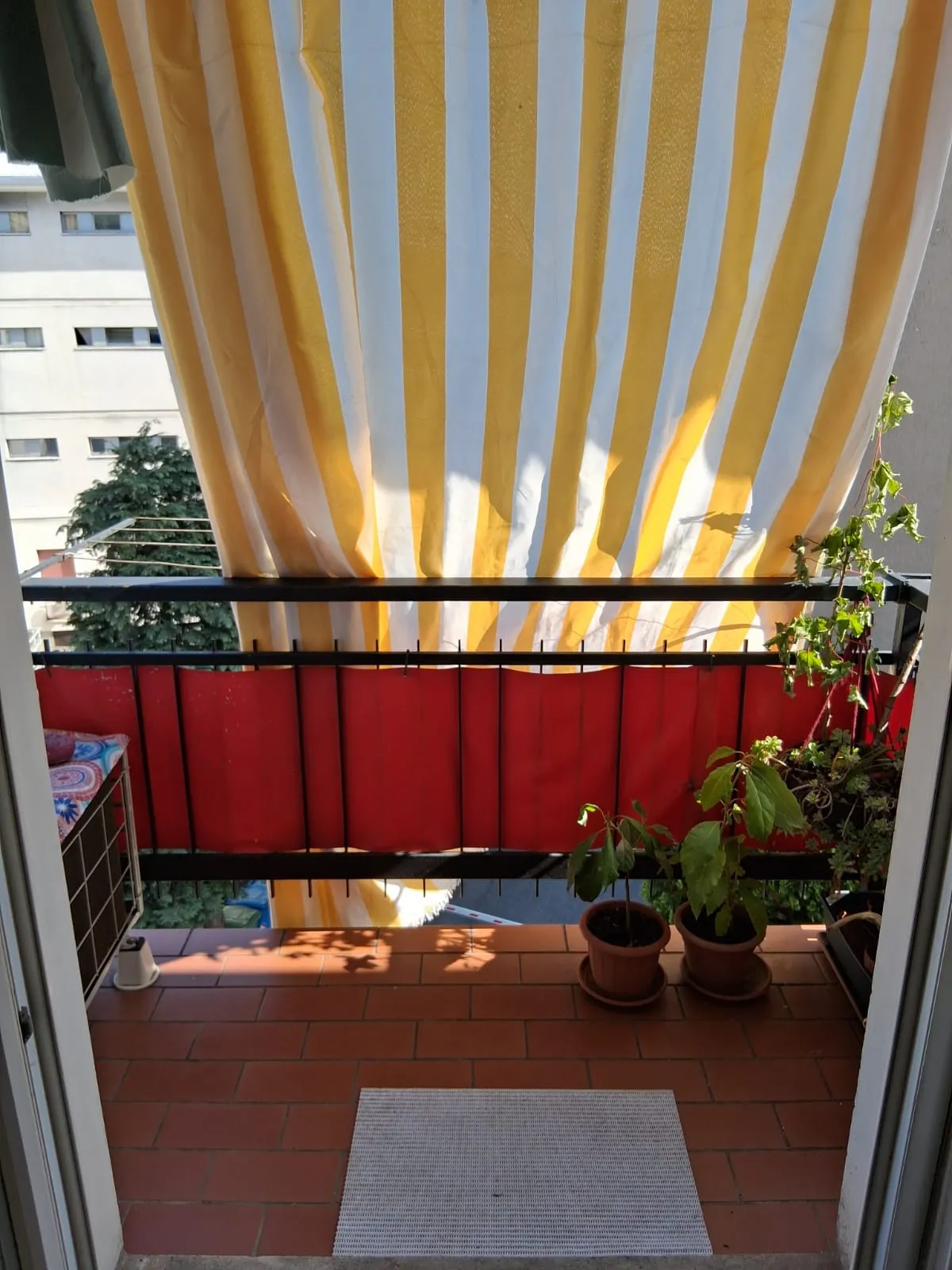 Le petit balcon privé, avec des plantes et un store rayé